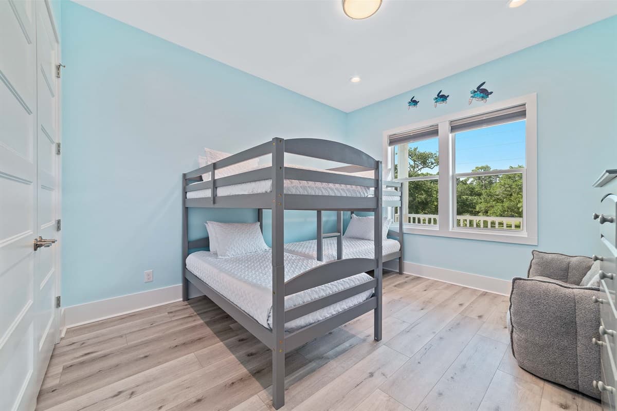 This bright bedroom features a sturdy bunk bed, offering comfortable sleeping arrangements in a cheerful setting.