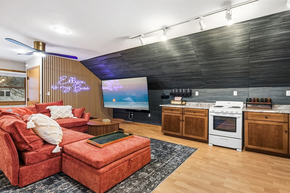 For those who love a bit of flair, you can switch on neon mood lighting to add a glitzy vibe. Or, grab some popcorn and sink into the sectional sofa in front of the 75-inch TV for the perfect movie night.