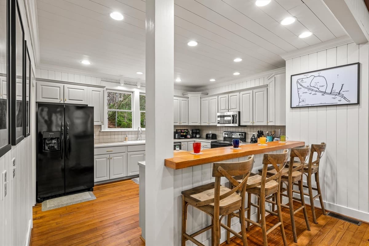 Kitchen with Black French Door Refrigerator, Butcher Block Island and White Shaker Cabinets – featuring our private trail map with a 'You Are Here' sticker to help you plan your next hike or outdoor adventure