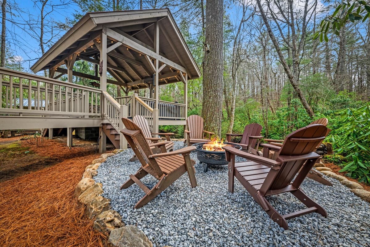 Fire Pit Area Directly on the River with Adirondack Chairs Below the Covered Walkway and Deck Structure