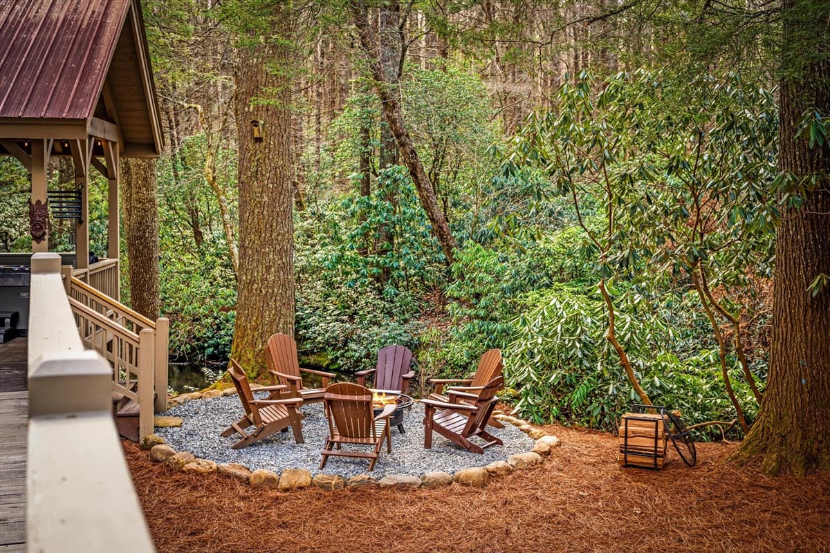 Circular Fire Pit with Adirondack Chairs Directly on the River, Nestled Among the Tall Trees