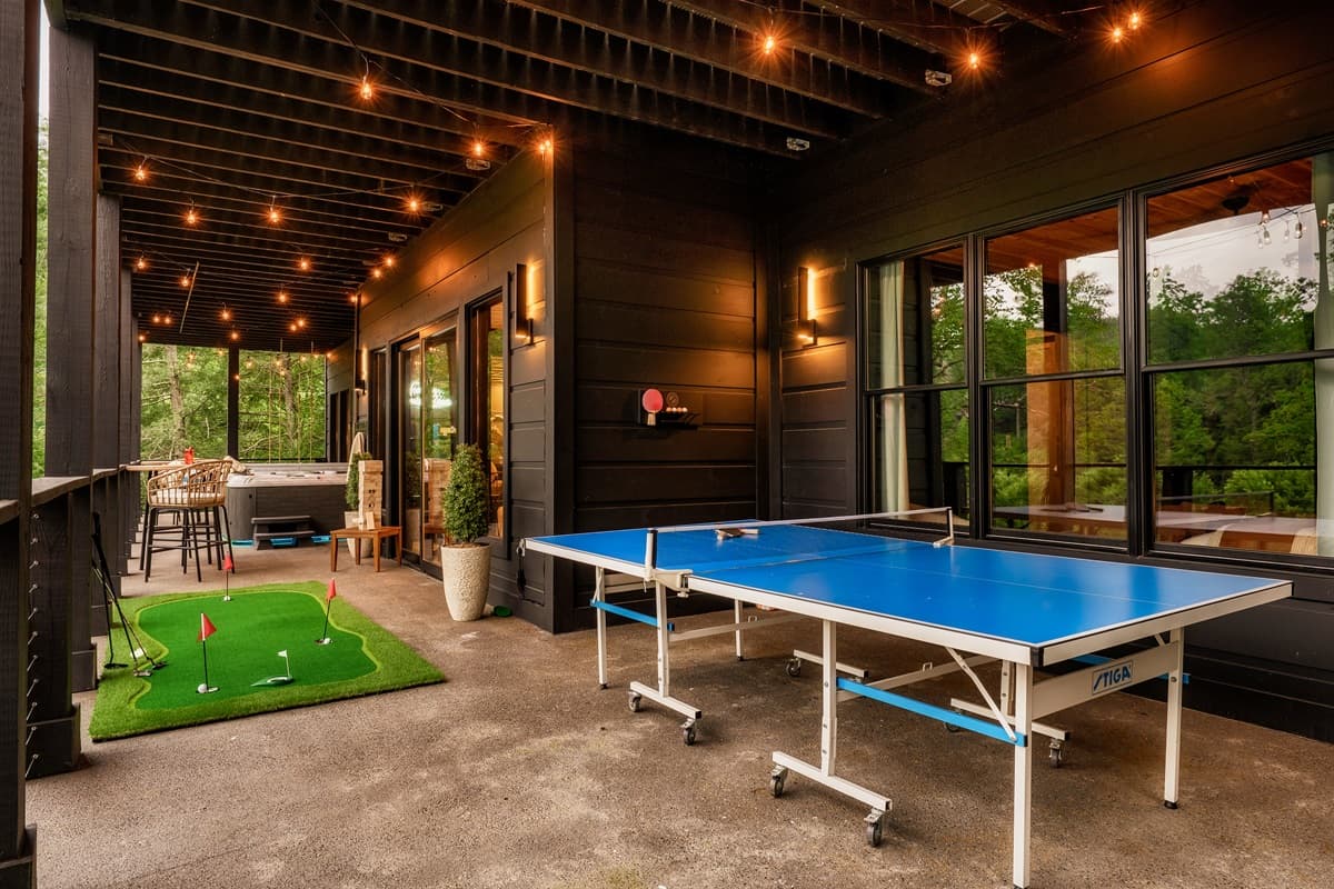 This dynamic game room features a full-sized billiard table, a ping-pong table, and large windows offering scenic views.