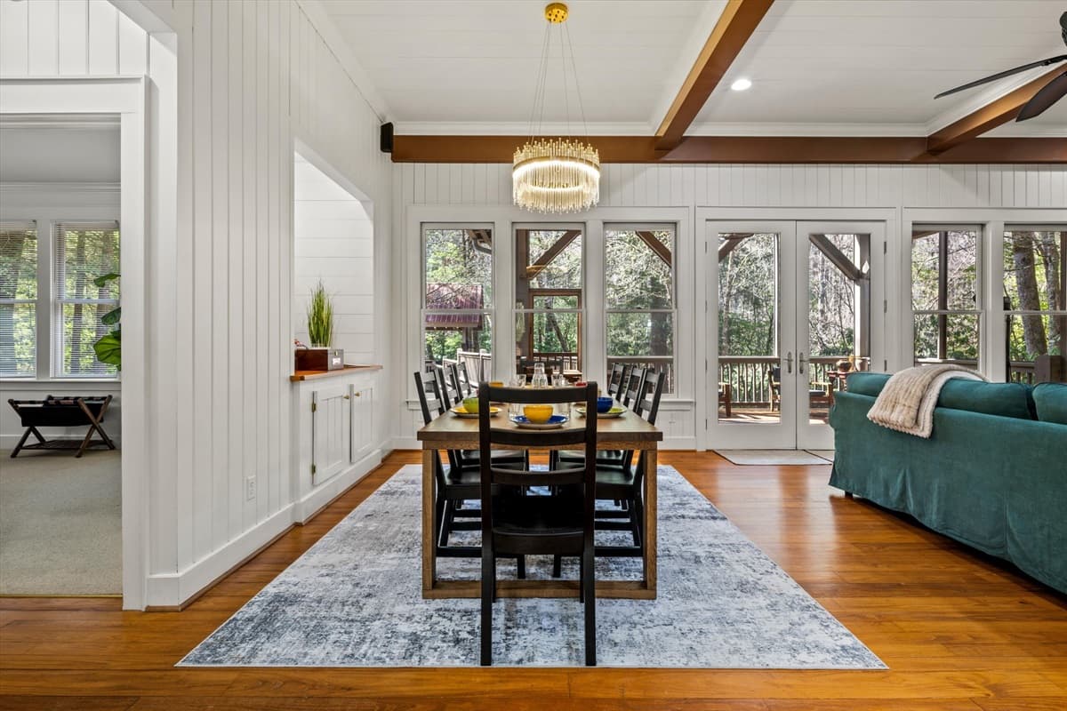 Bright Dining Room with Large Table, Blue Chairs and Panoramic Forest Windows
