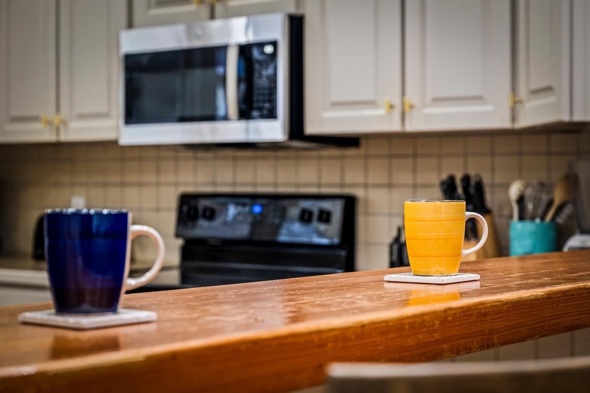 Kitchen Counter with Coffee Mugs, Microwave and Stocked Utensil Holder