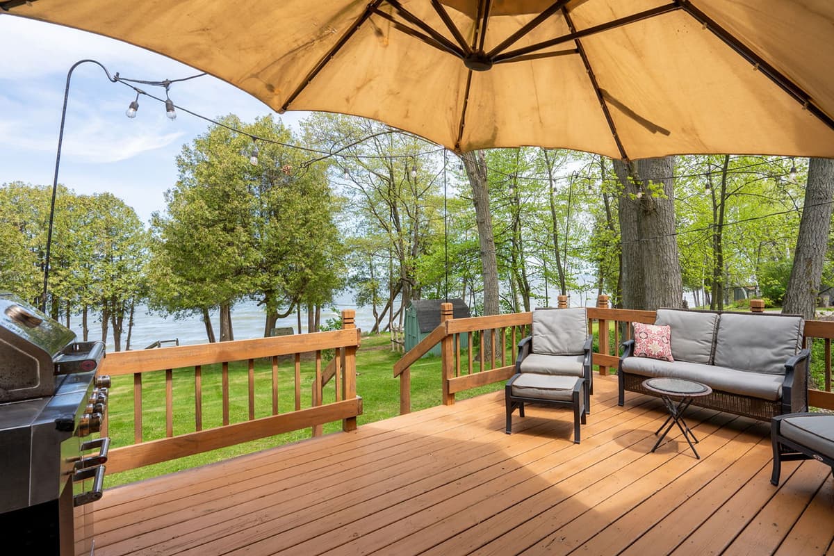 A large umbrella provides shade, making the patio a pleasant spot to enjoy meals or spend time outdoors. Fire up the grill for a casual barbecue or gather around the table for an al fresco meal.