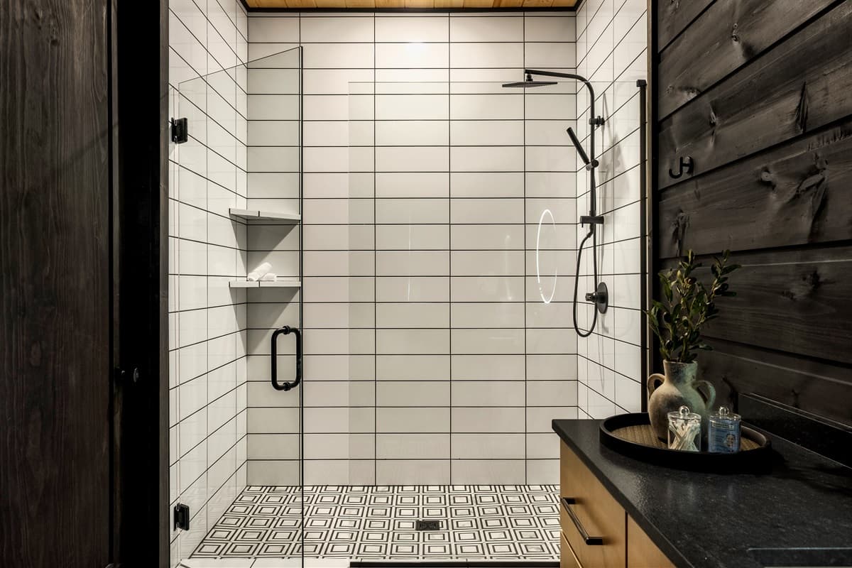 This bright and modern bathroom features a spacious walk-in shower with white subway tiles and convenient built-in shelving.