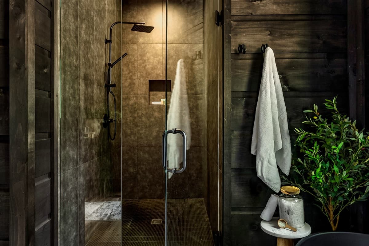 Indulge in a rejuvenating experience in this modern walk-in shower, featuring sleek black fixtures and a spa-like ambiance.