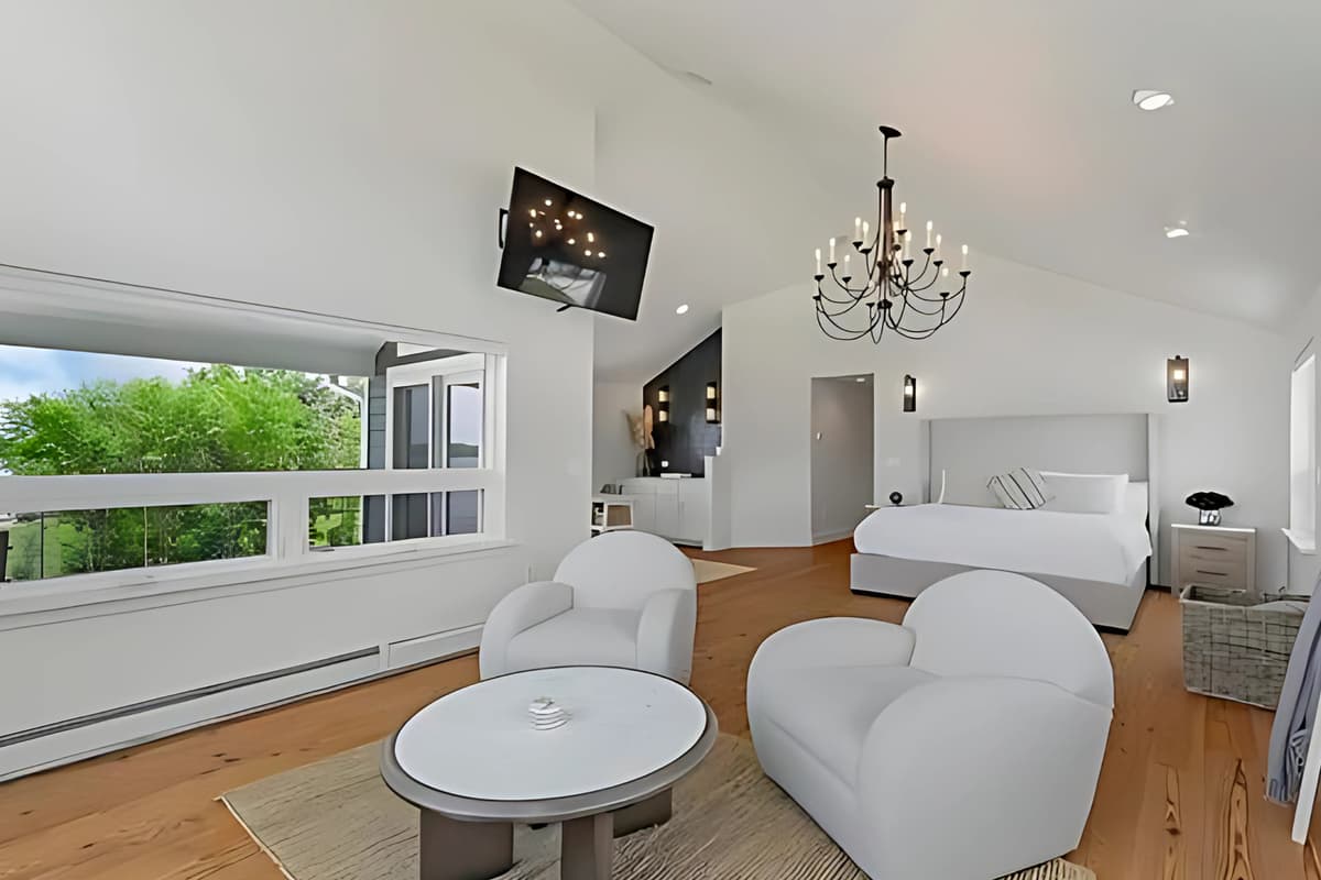 The spacious master suite features a comfortable king-size bed and large windows overlooking the lake.
