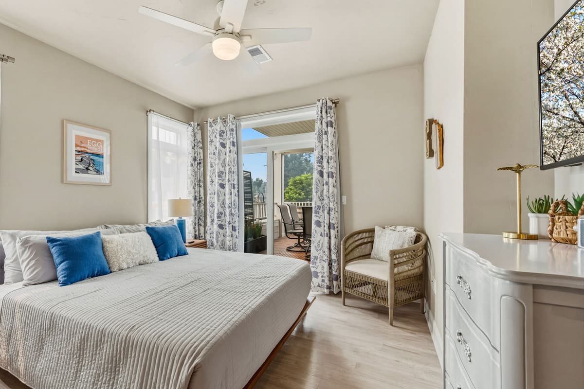 Sliding glass doors fill the bedroom with natural light and open directly onto the outdoor deck.