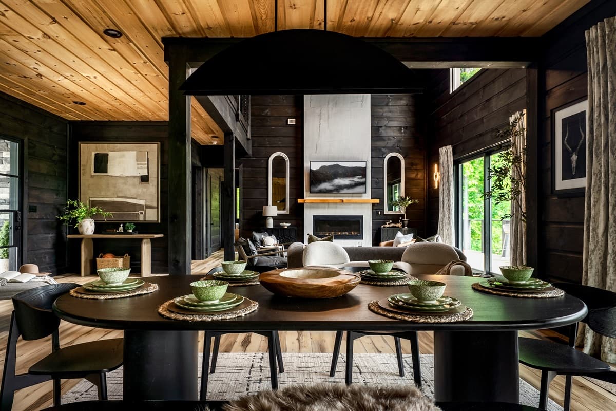 This elegant dining area, featuring a large oval table set with modern dishware, seamlessly connects to the inviting living room.