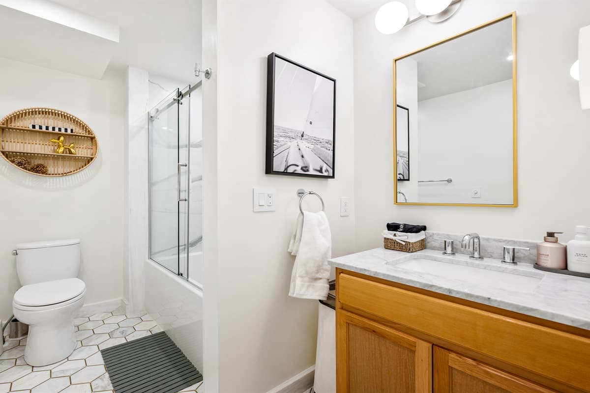 With sleek, contemporary finishes and plenty of space, this shared bathroom makes getting ready for the day or unwinding at night a breeze.