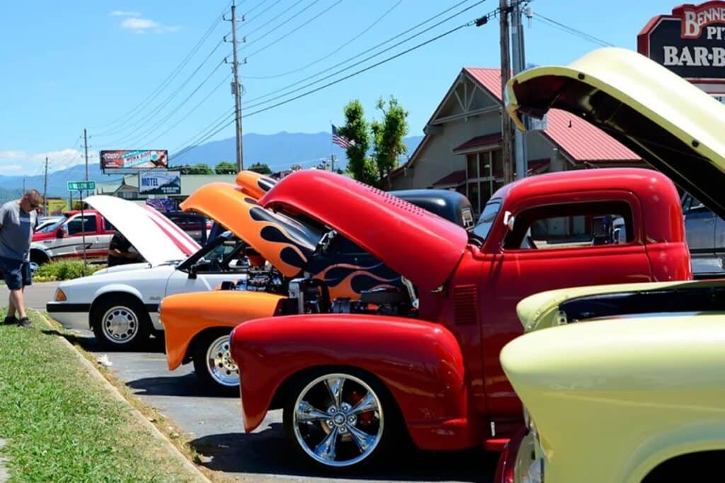 Classic cars lined up on the street during the Pigeon Forge Rod Run with visitors walking by