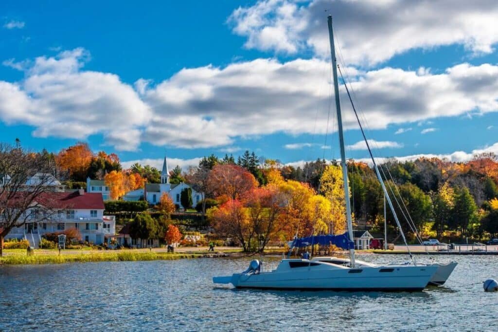 Sailboats docked at a Door County marina at sunset with calm water and pier lights