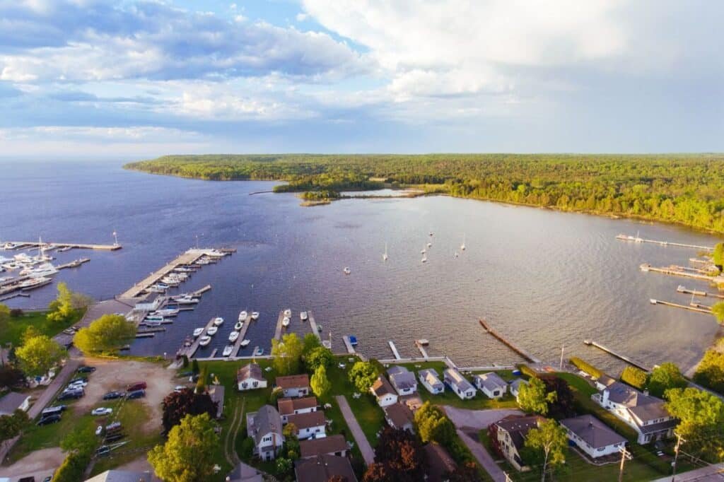Sailboats docked at a Door County marina at sunset with calm water and pier lights