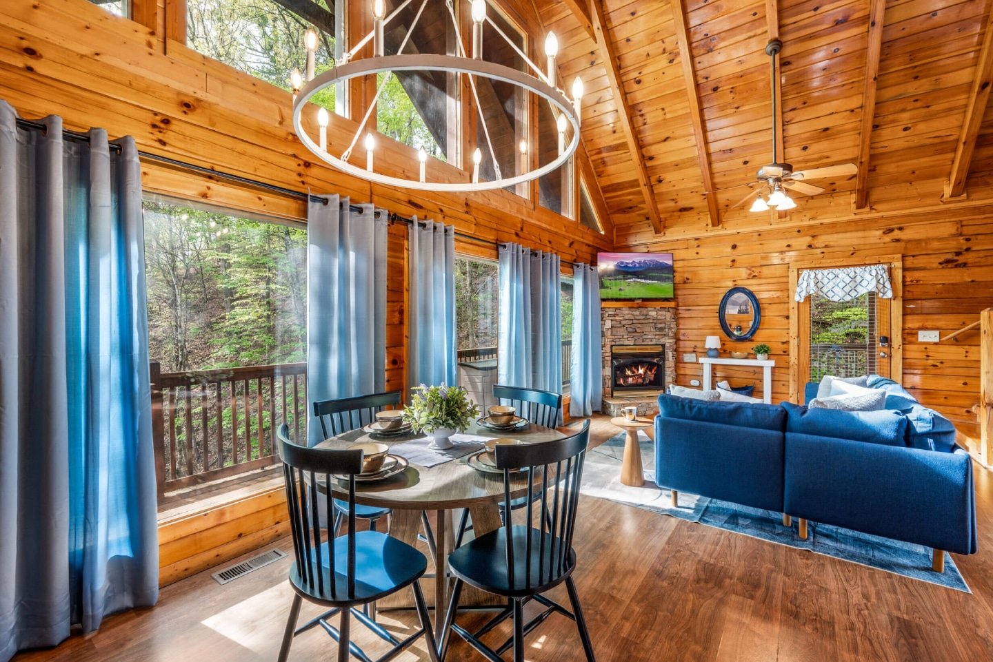 Experience the grandeur of our open-concept living space, where a stylish dining area flows seamlessly into a comfortable lounge with a fireplace and large TV. Expansive windows frame breathtaking outdoor views, making this the ideal hub for gathering and