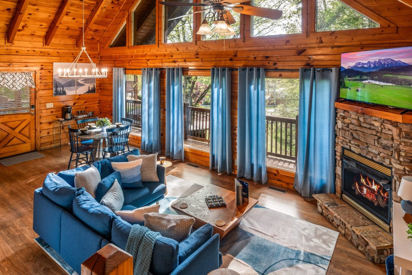 This beautifully appointed open-plan cabin interior seamlessly connects the comfortable living room, dining area, and full kitchen, making it perfect for family and friends to gather. Enjoy the inviting ambiance created by the warm wood finishes and stylis