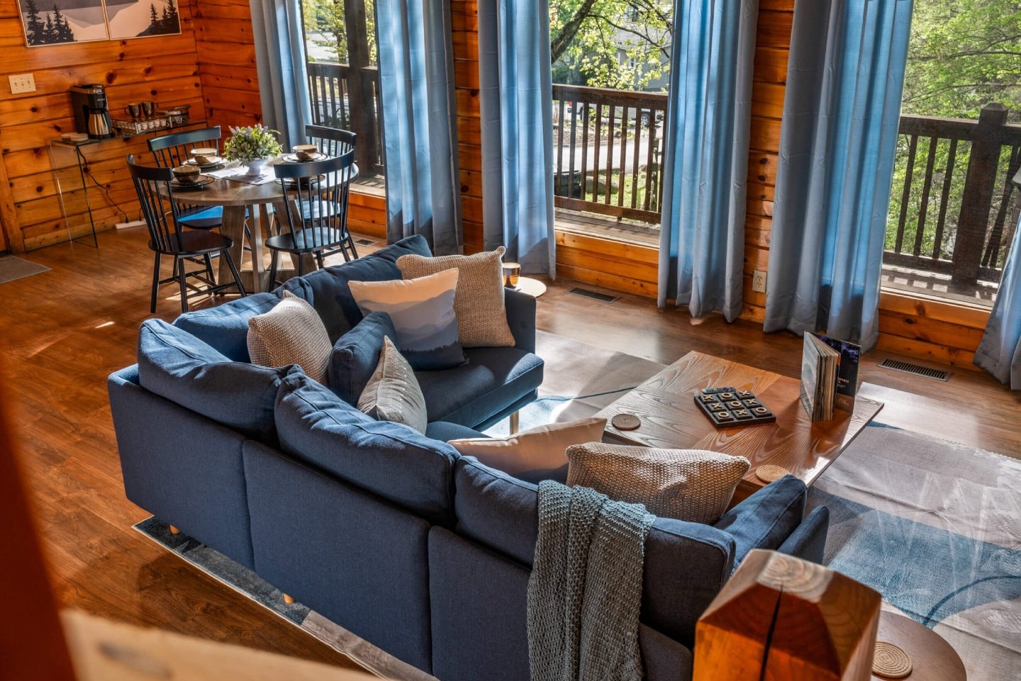 Step into the spacious living area, boasting soaring ceilings and large windows that frame picturesque views, creating an airy and bright ambiance. Relax by the warm fireplace on the plush sofas, or gather for a meal in the adjacent dining area, perfect fo