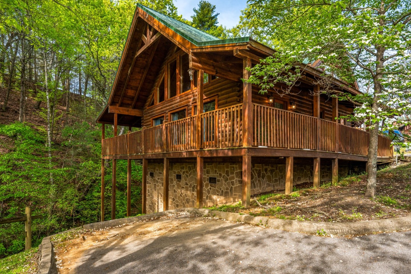 Perched among the trees, this stunning multi-level log cabin offers breathtaking views from its expansive wraparound deck. Its impressive design and elevated setting provide a truly memorable and private escape for your vacation.